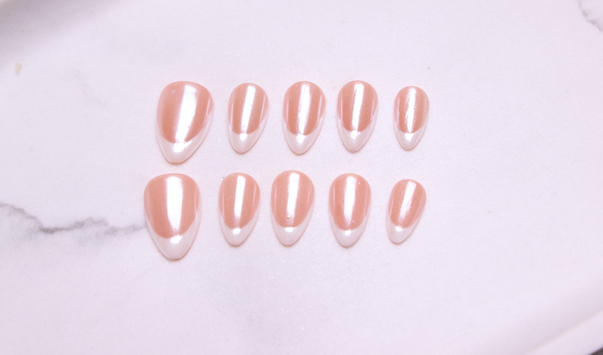 Flatlay av ti mandelformede løsnegler i nude med hvit french-tupp
